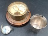 une horloge et une tasse posées l'une à côté de l'autre sur une table