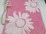 a pink bag with white flowers on it sitting on a table
