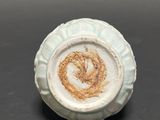 a close up of a small ceramic object on a table