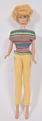 poupée Barbie aux cheveux blonds, vêtue d'un t-shirt rayé et d'un pantalon jaune