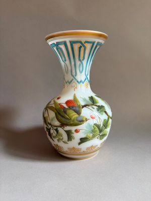 un petit vase orné d'un oiseau, posé sur une table