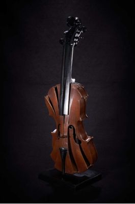 statue of a cello on a stand against a black background