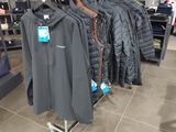 un portemanteau dans un magasin de vêtements, sur lequel sont suspendus des vêtements