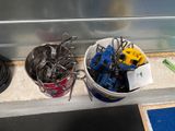 a bucket full of tools sitting on the floor next to a trash can