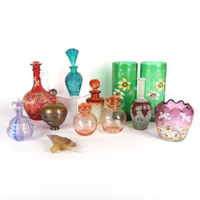 de nombreux vases en verre de différentes couleurs posés sur une surface blanche