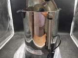 une cafetière posée sur un sac en plastique dans un coin de la pièce