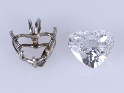 deux pendentifs en forme de cœur sertis de diamants sur un fond blanc