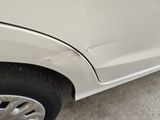 a white car that has a dent in the side of it