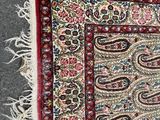 an oriental rug with a paisley design and fringes on it