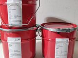 trois seaux de peinture rouge posés sur un plan de travail blanc
