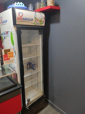 un réfrigérateur qui se trouve dans le coin d'une pièce