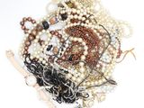 a pile of pearls and other jewelry on a white surface