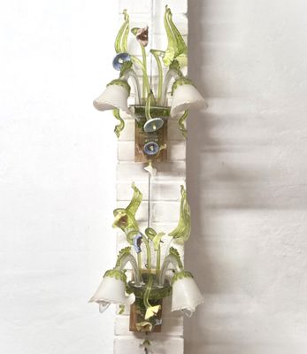 two vases that have flowers in them hanging on a wall