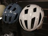 several helmets are lined up on a rack in a bike shop