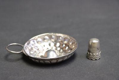 un dé à coudre en argent et un dé à coudre en argent posés sur une table