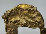a gold colored mirror with a picture of a man and a dog on it