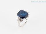 a close up of a ring with a blue stone on it