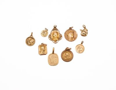 a close up of a group of gold charms on a white surface