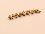 a close up of a gold hair clip on a white surface