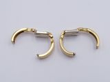 a pair of gold earrings on a white surface