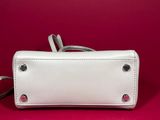 a white purse sitting on top of a red surface