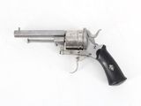 an old revolver with a black handle on a white surface