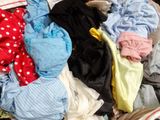 a pile of clothes sitting on top of a bed