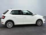 a white car parked in a parking lot next to a white wall