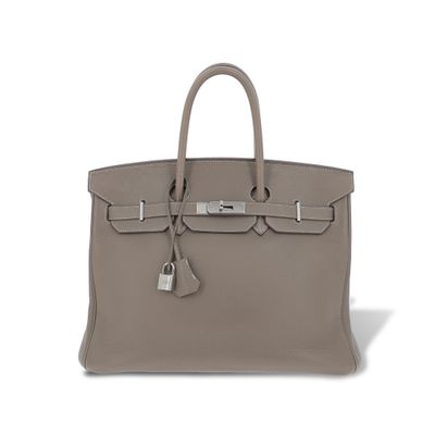 a grey leather bag with a lock on the handle