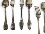 a lot of silver spoons and forks on the table