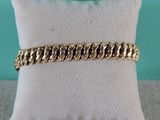 un bracelet en chaîne d'or posé sur un coussin