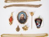 an image of a collection of jewelry including a necklace, broochi, and a picture of a man
