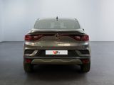 the rear end of a silver car in a room with a white wall