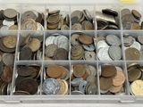 une boîte en plastique remplie d'une multitude de pièces de monnaie posée sur une table
