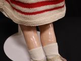 a close up of a doll wearing a red and white dress