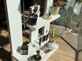 a white shelf with plants on it in a room