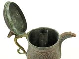 a small metal tea pot with a lid on a white surface