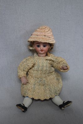 a doll that is sitting on the floor wearing a hat