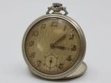an old pocket watch sitting on top of a white surface