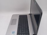 a silver laptop with a black keyboard on a white surface