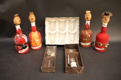 bottles of wine and wine glasses are lined up on a table