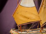 a small model of a sailboat on a wooden table