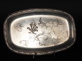 une assiette en argent ornée d'un motif sur fond noir