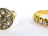 two gold rings with diamonds on them sitting next to each other