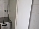 a small refrigerator in the corner of a small kitchen