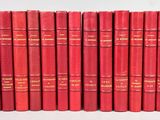 Les livres rouges sont alignés en rang sur une surface blanche.