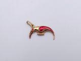 a gold charm with a red bird on it ' s side