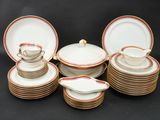 a group of white and gold china dishes and cups and saucers