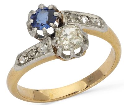 a close up of a diamond and sapphire ring on a white background