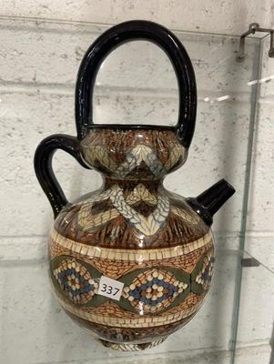 un vase muni d'une anse, exposé dans une vitrine